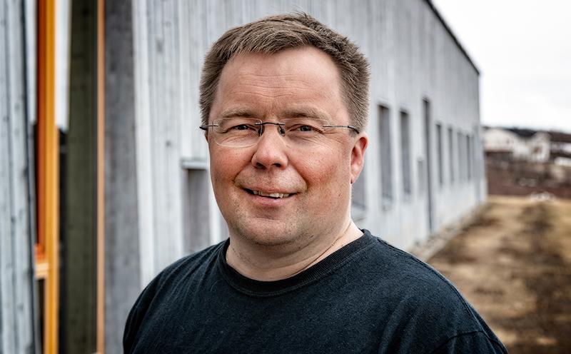 Smilende mann som står ute en høstdag i Troms og Finnmark.