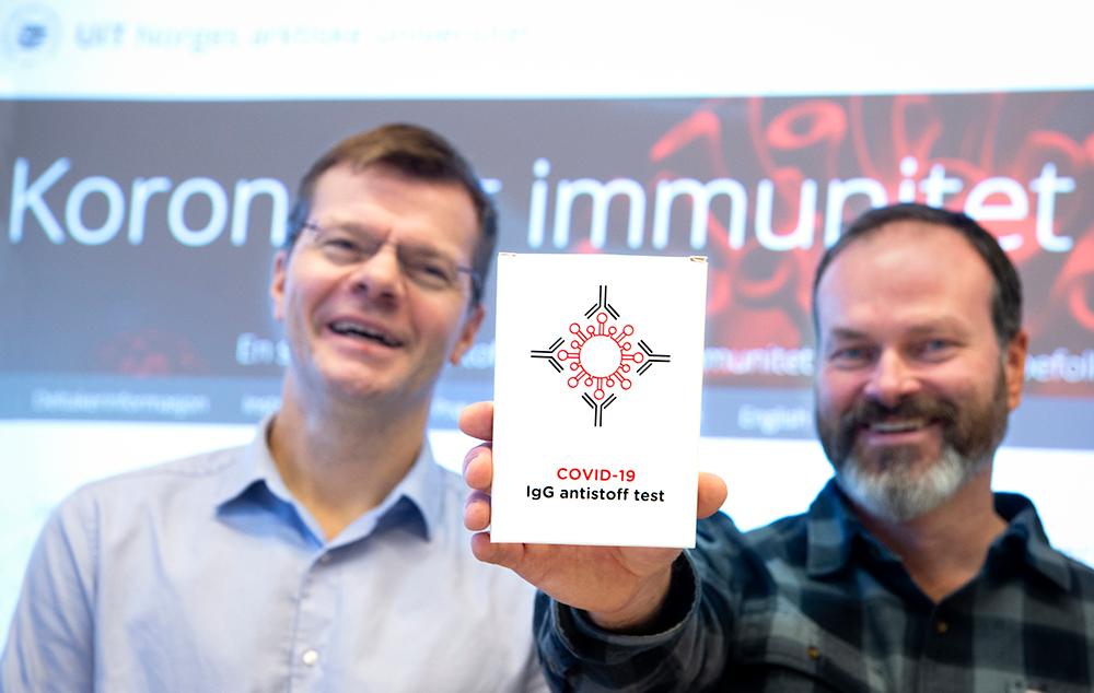 2 menn som holder opp en blodpr&oslash;ve pakke