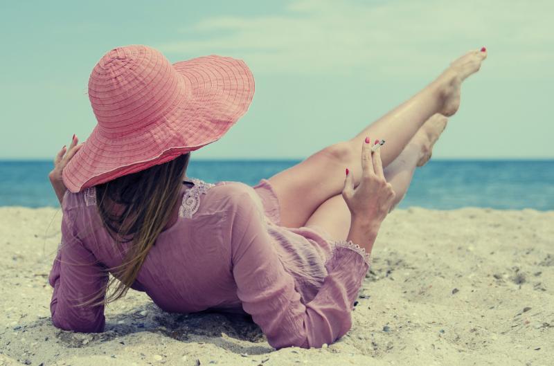 Dame p&aring; strand med sigarett i h&aring;nden