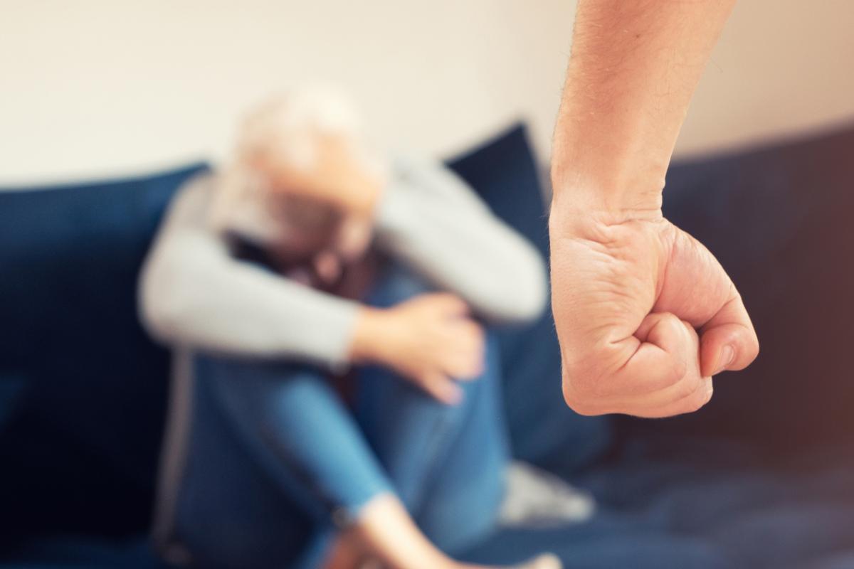 Knyttet h&aring;ndneve og kvinne i sofa