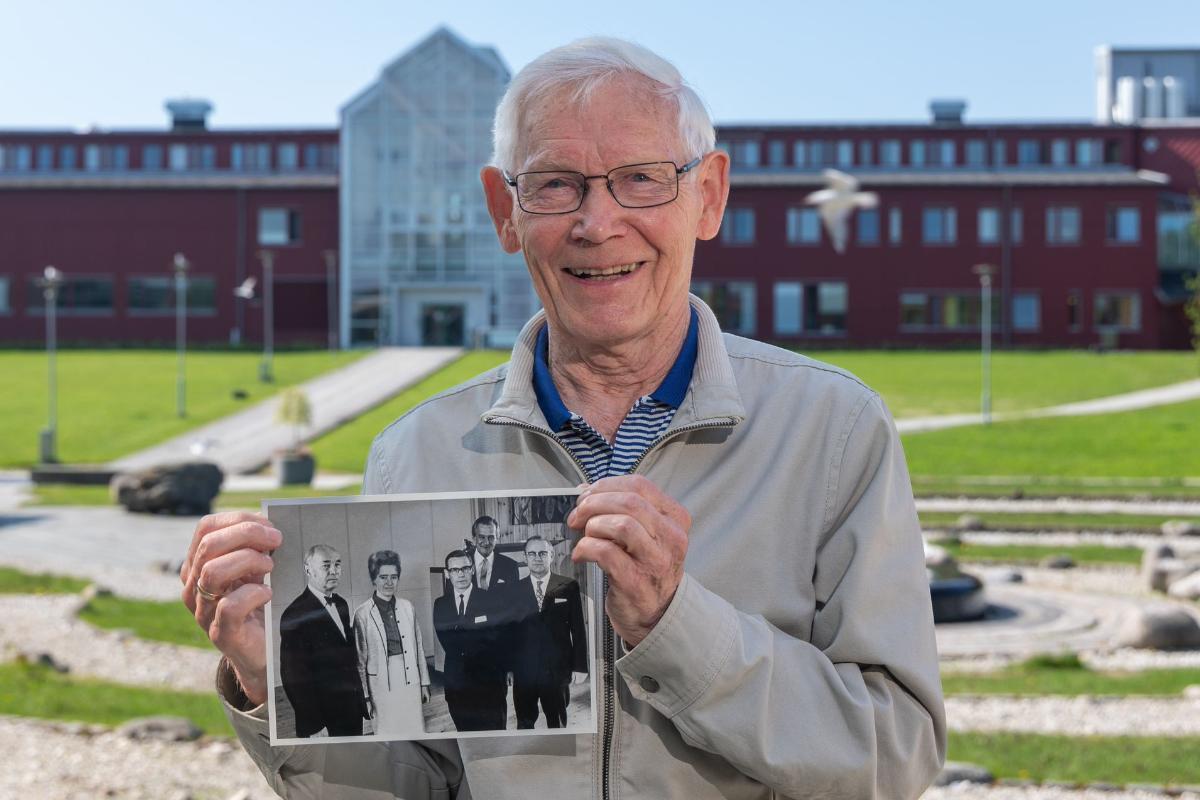 eldre mann som holder opp et gammelt bilde fra UiT