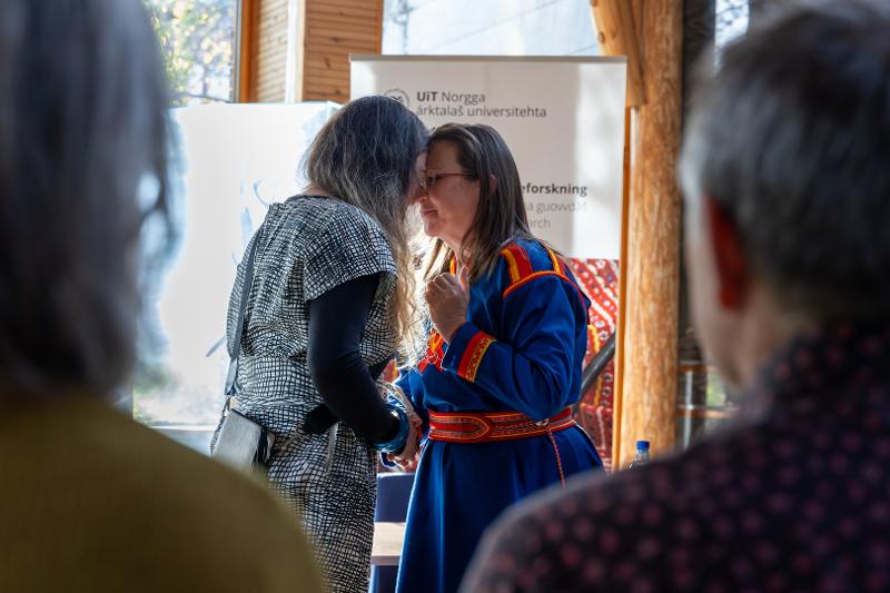 Emma_Rawson_Te_Patu_og_Ann_Ragnhild_broderstad__UIT_23063.jpg To kvinner står panne mot panne. Biletet er tatt frå mellom to tilskodarar.