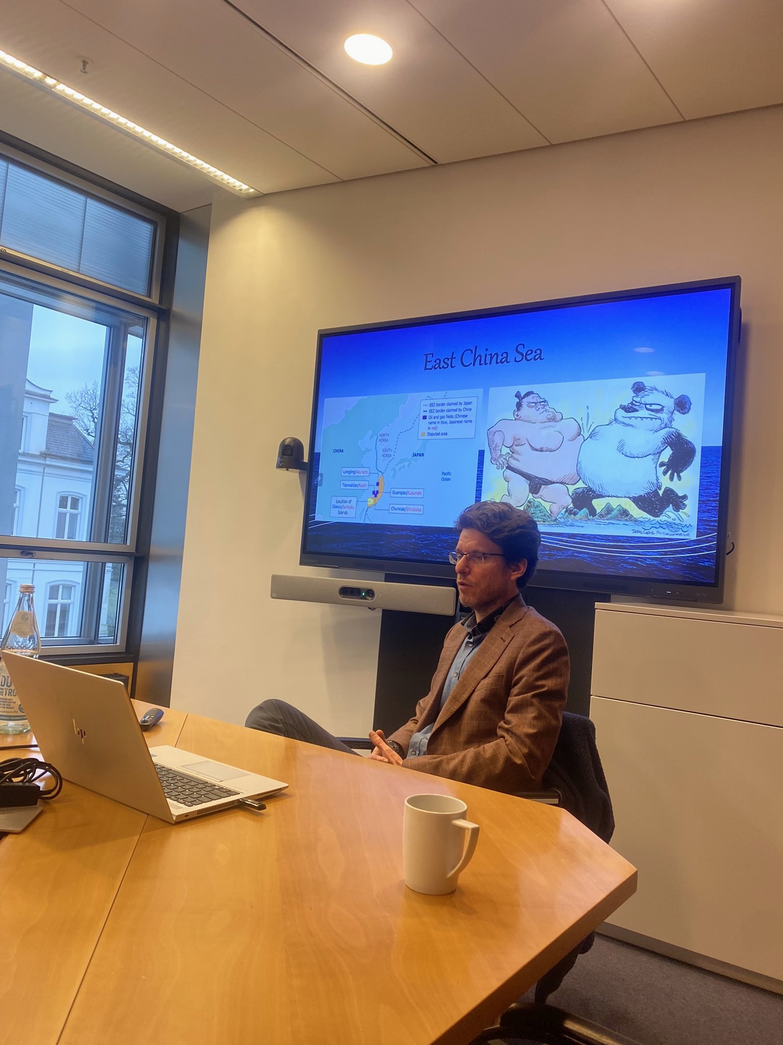 Youri van Logchem sitting at a table and presenting a powerpoint