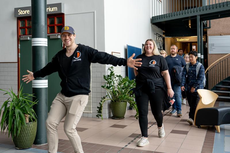 Glade studenter ved inngangen til et undervisningsrom. 