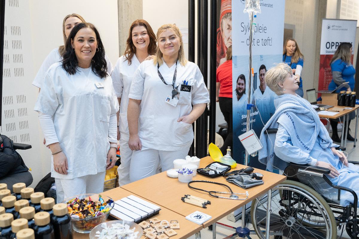 Personer som st&aring;r rundt et bord