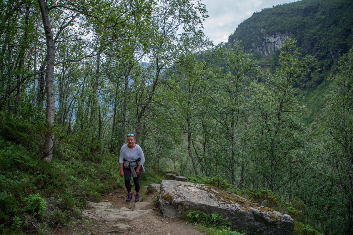 dame som går tur i bratt skogterreng