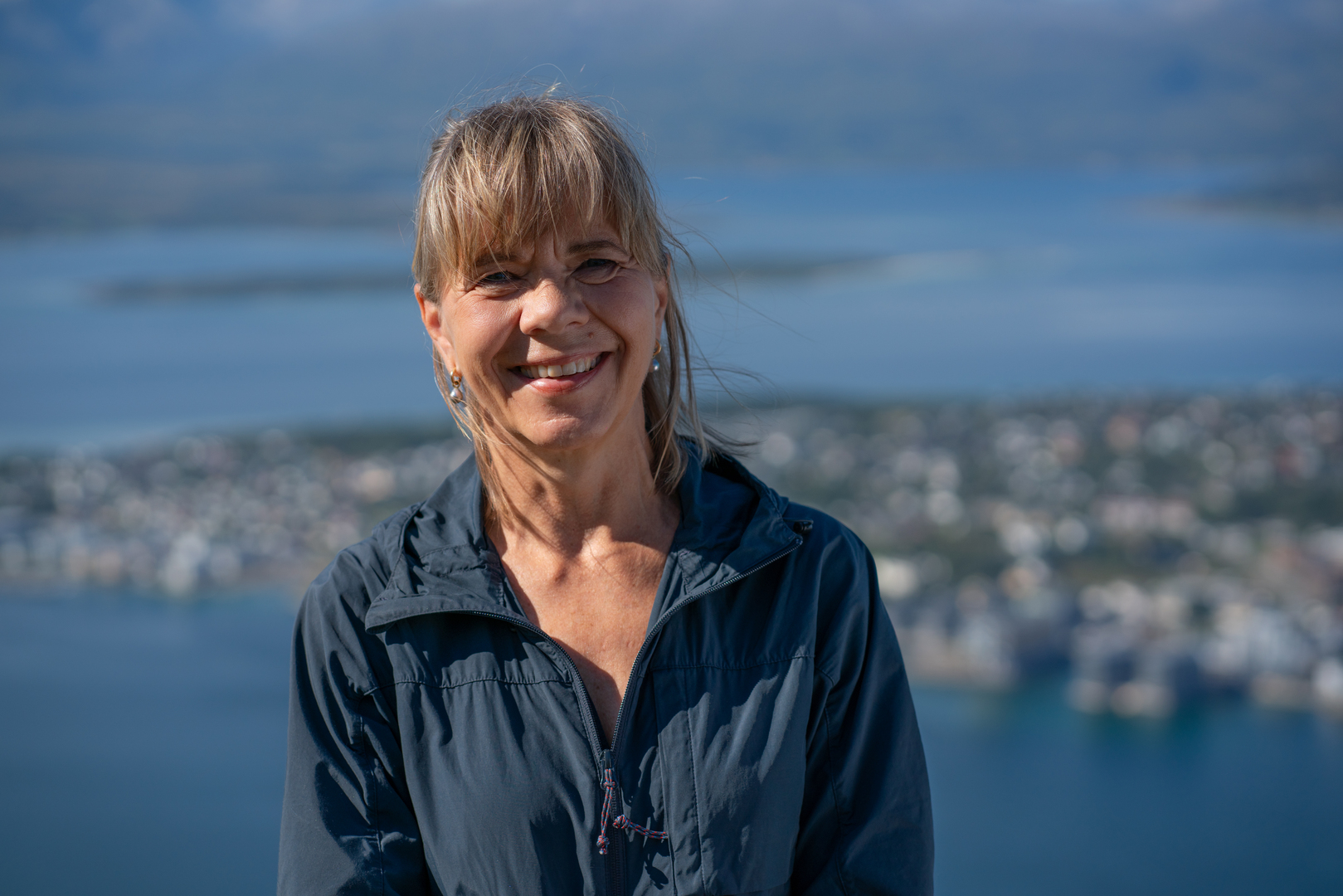 dame som står på fjellet og smiler