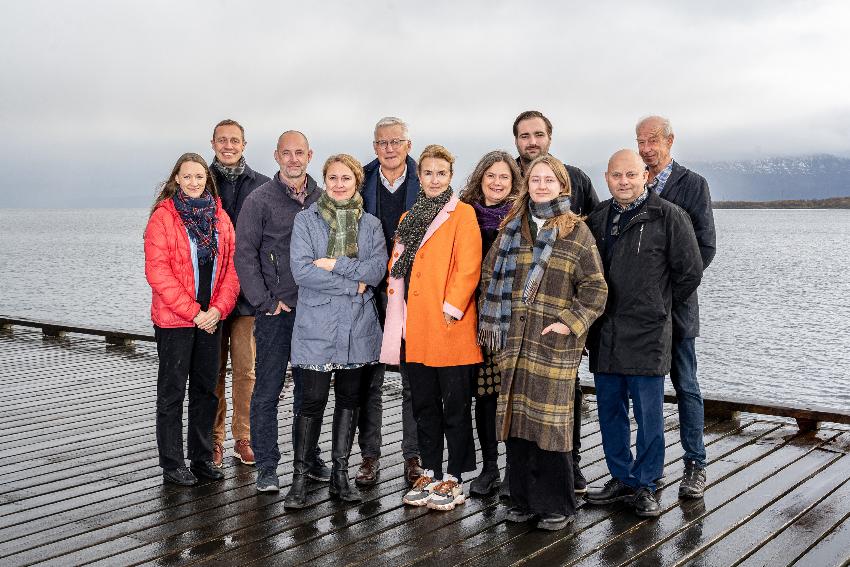 Flere personer st&aring;r p&aring; en kai. 