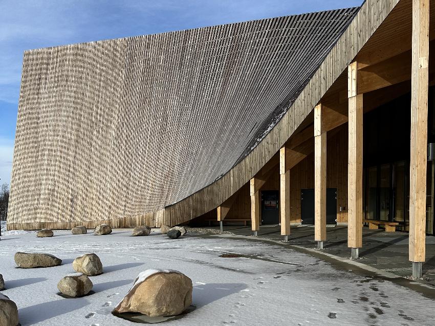 arkitekttegnet bygg med tak som buer seg nedover 