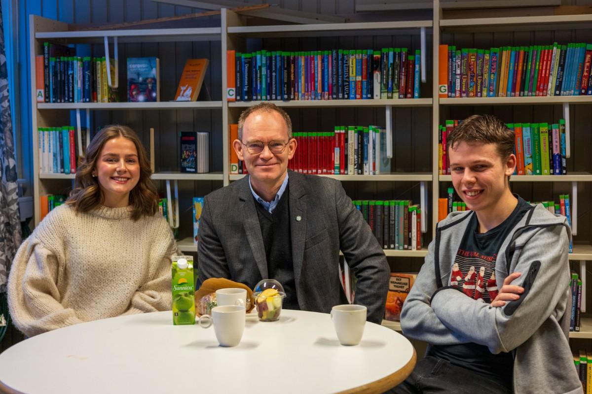 Smilende mennesker p&aring; et skolebibliotek