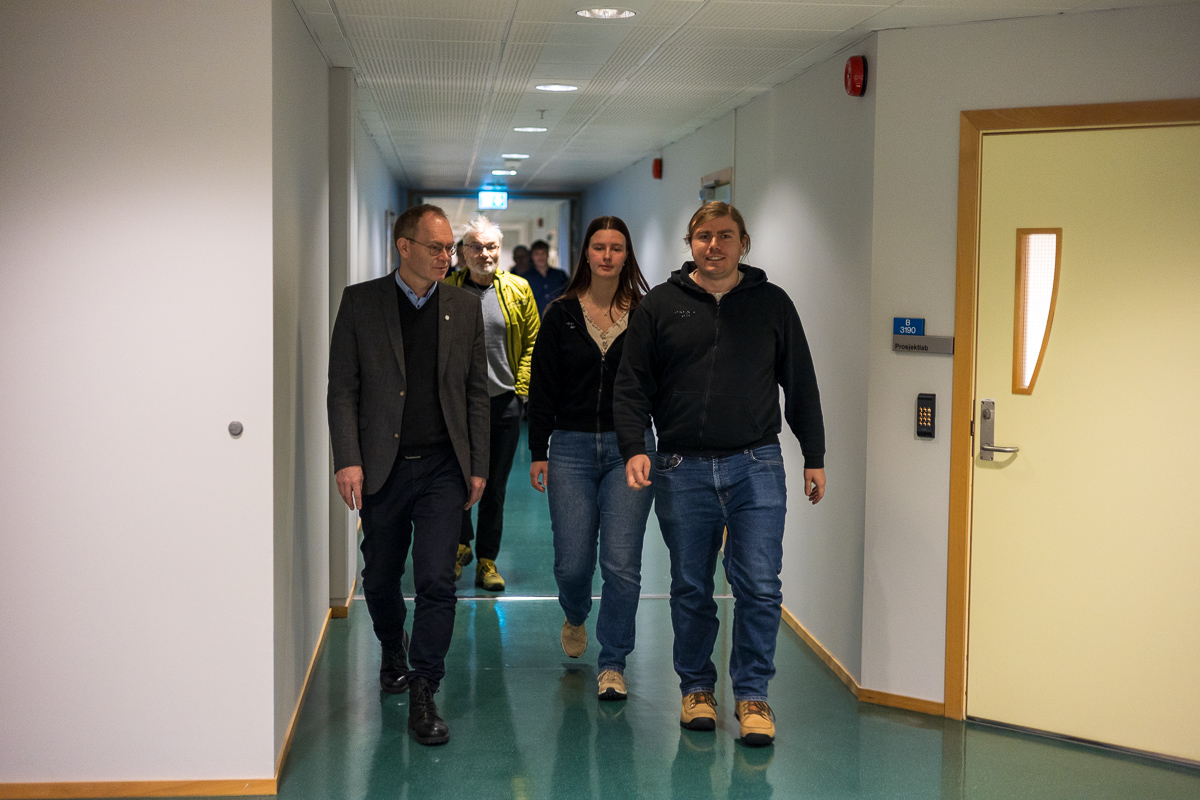 Mennesker g&aring;r i en korridor