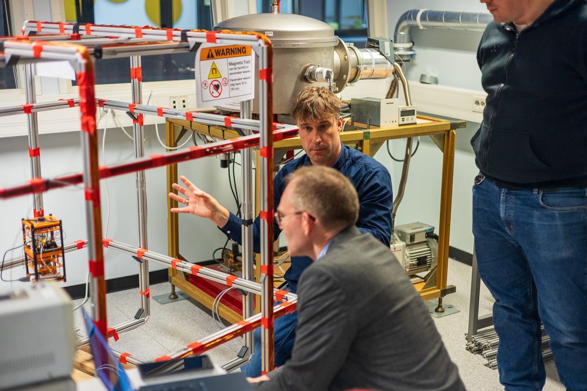 Mann forklarer en annen mann ting inne p&aring; en teknisk lab