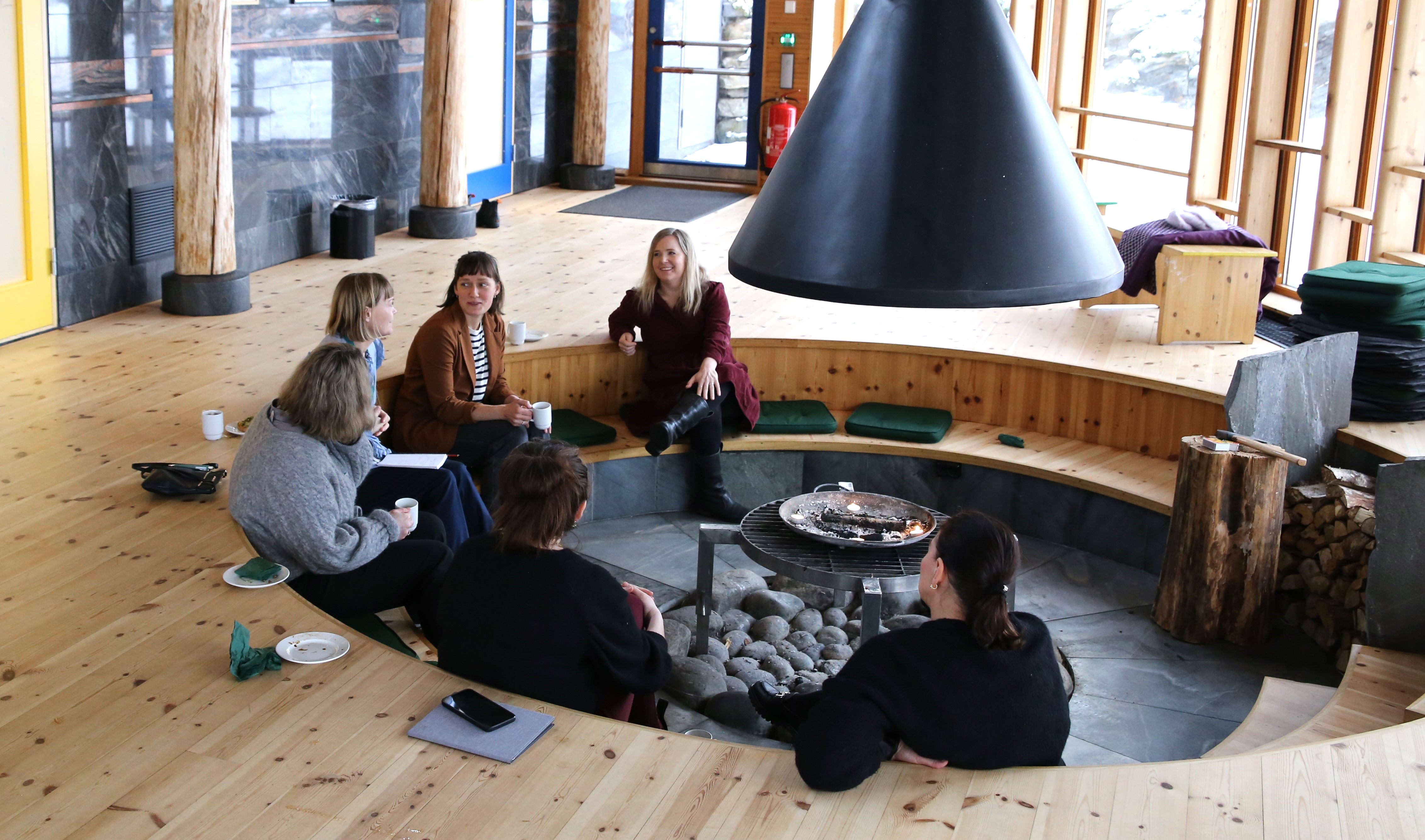 Participants of the seminar are sitting around the fireplace talking to eachother