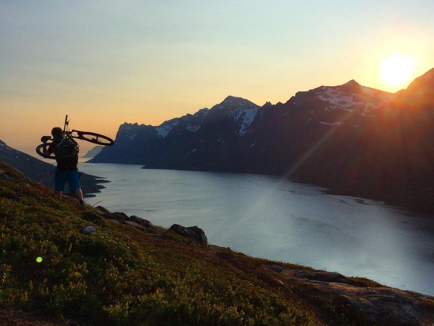mann som b&aelig;rer en sykkel p&aring; et fjell 