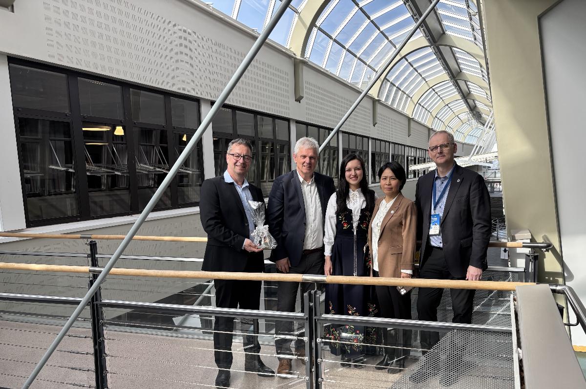 Fem personer smiler til fotografen