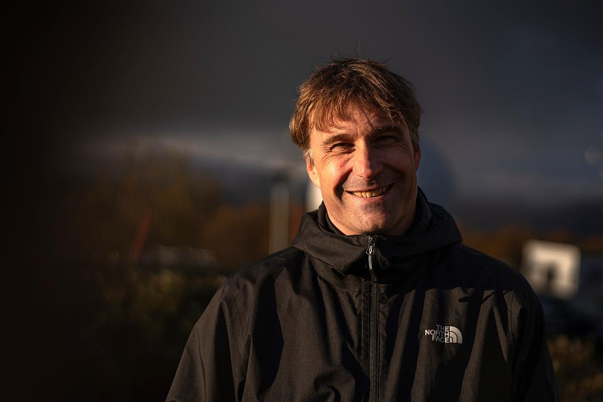 Bilde av person som står ute og smiler til kamera