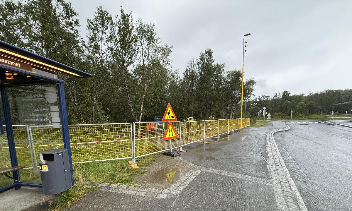 Viser den fysiske stengingen av stien fra Hansine Hansens veg og Botanisk hage. Den fysiske sperringen er gul og du ser busstoppet UiT/Planetariet i bakgrunnen 