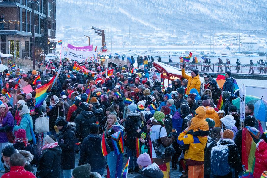 mange personer i pride tog med pride flagg mens det sn&oslash;r 