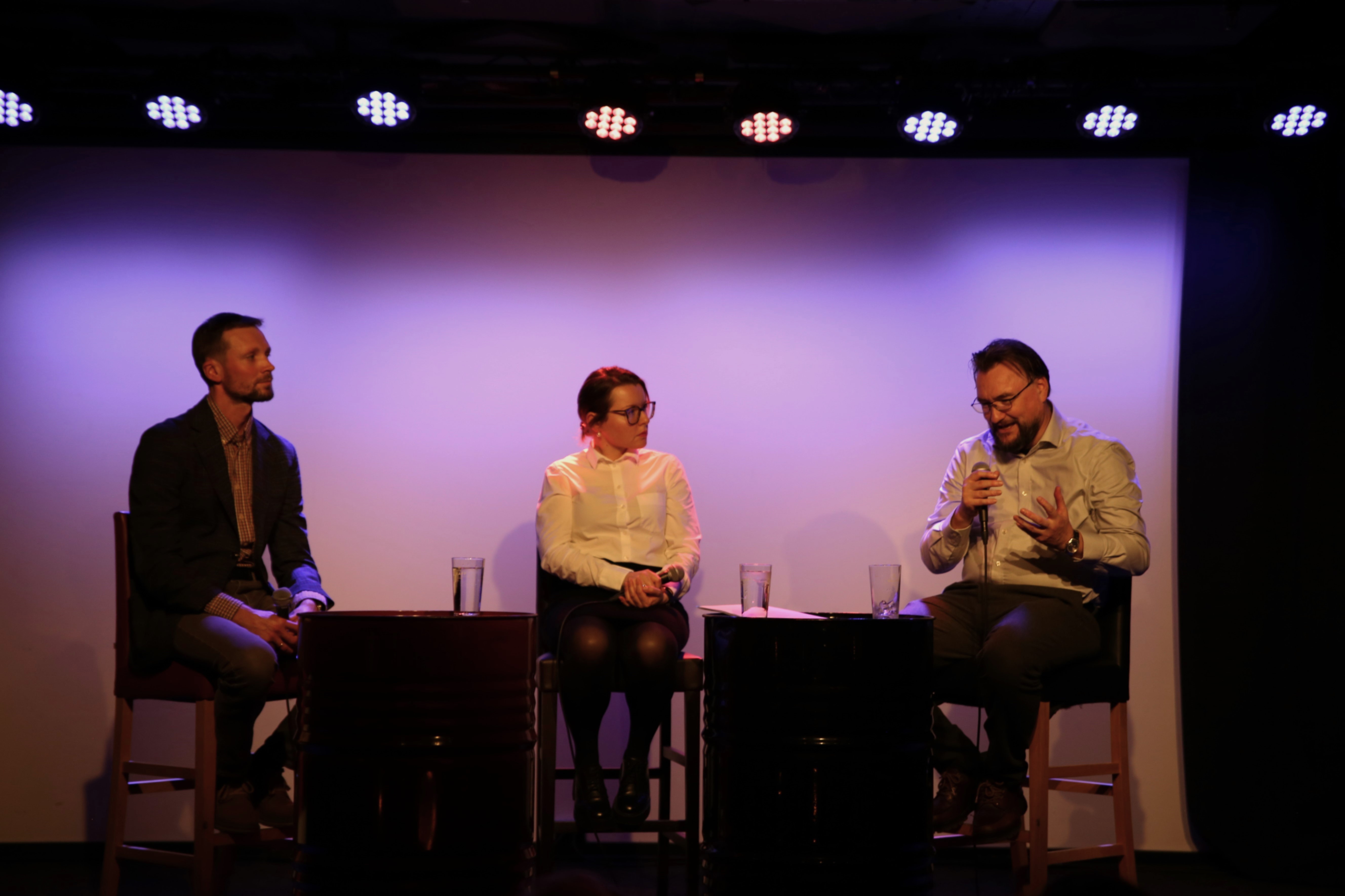 Tre paneldeltagere sitter på stol og er i en samtale. 