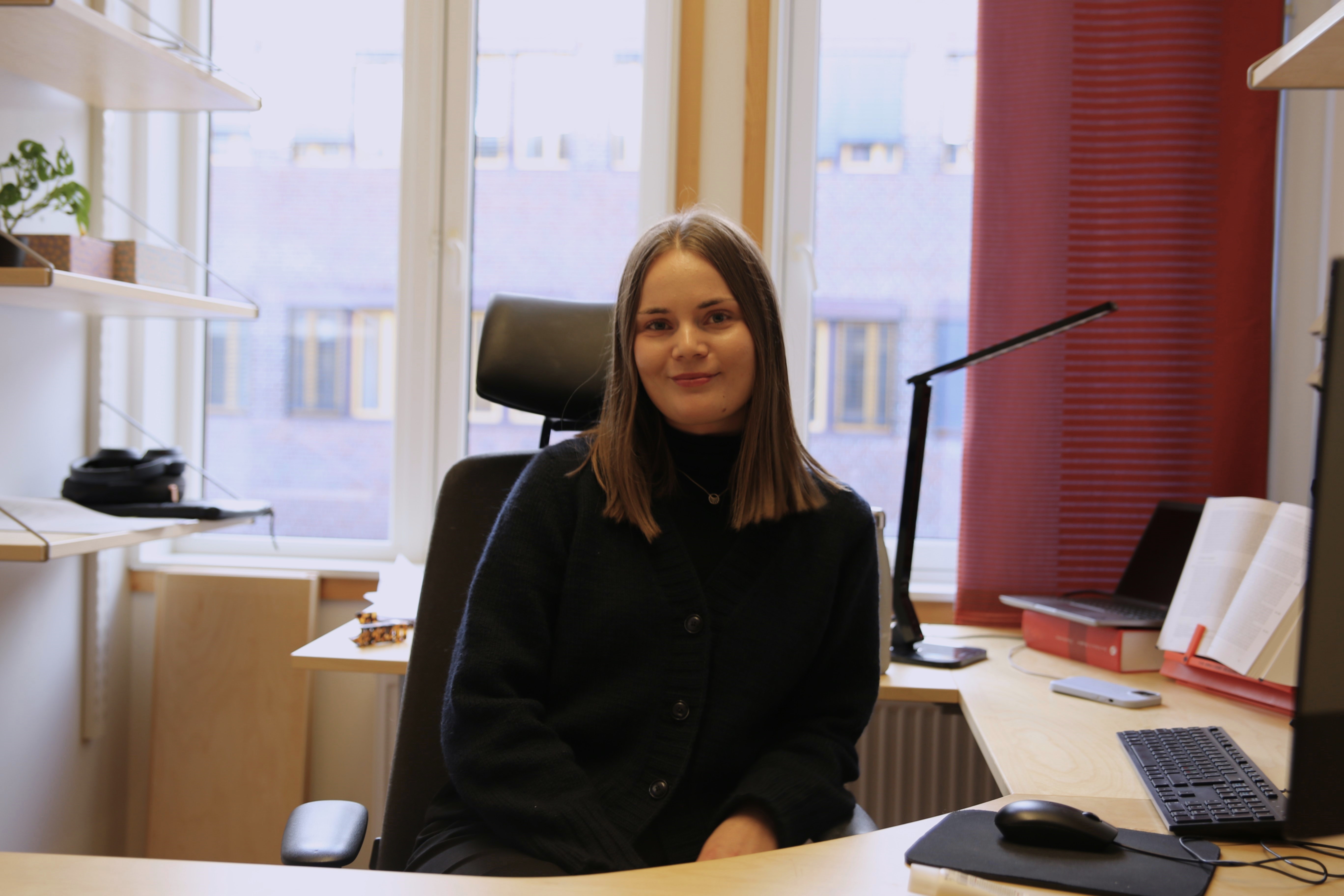 Jente på kontoret sitt i en stol.