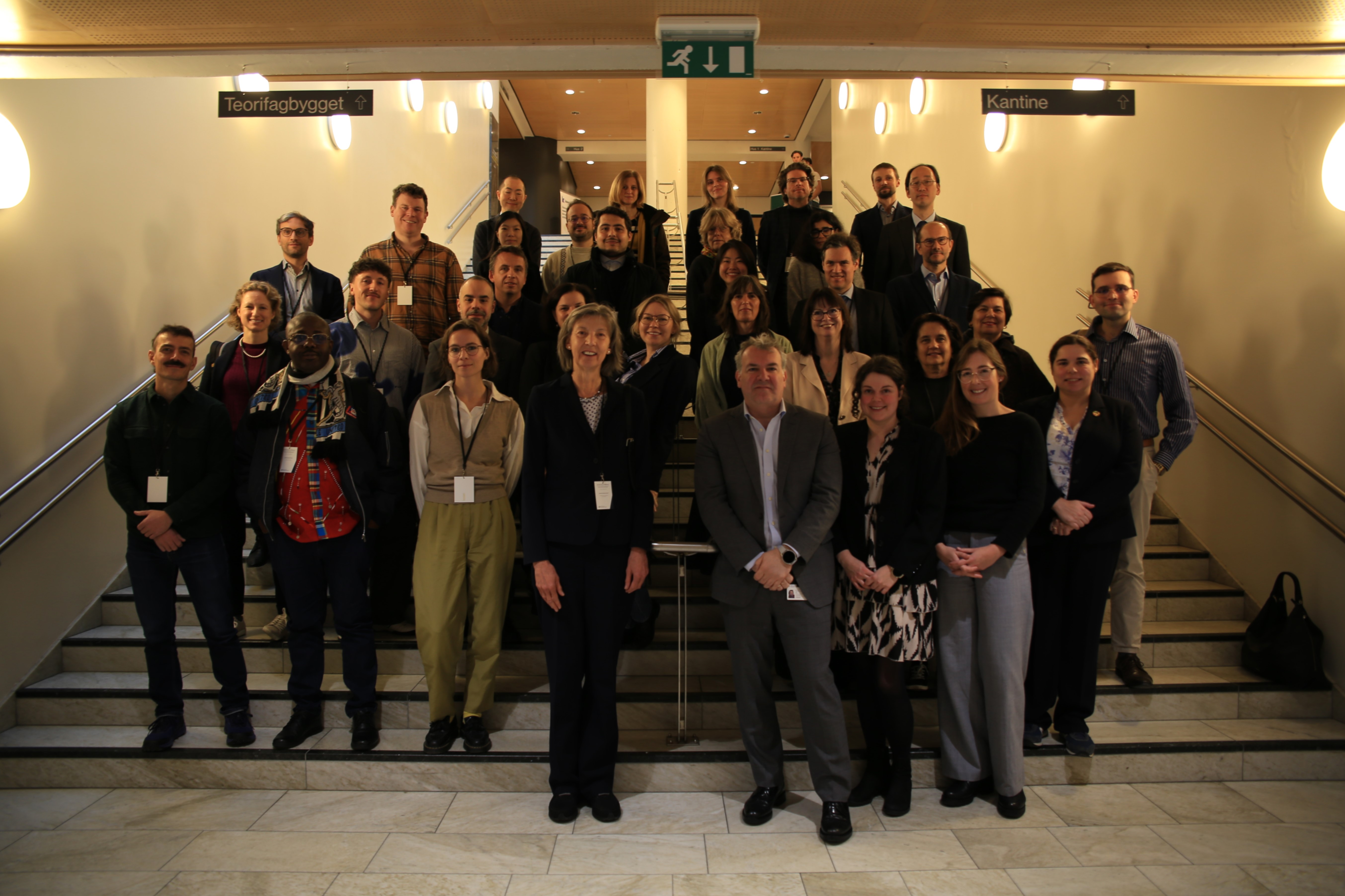 group photo of participants on day 1 of the conference, people standing in rows behind each other up a staircase, looking into a camera