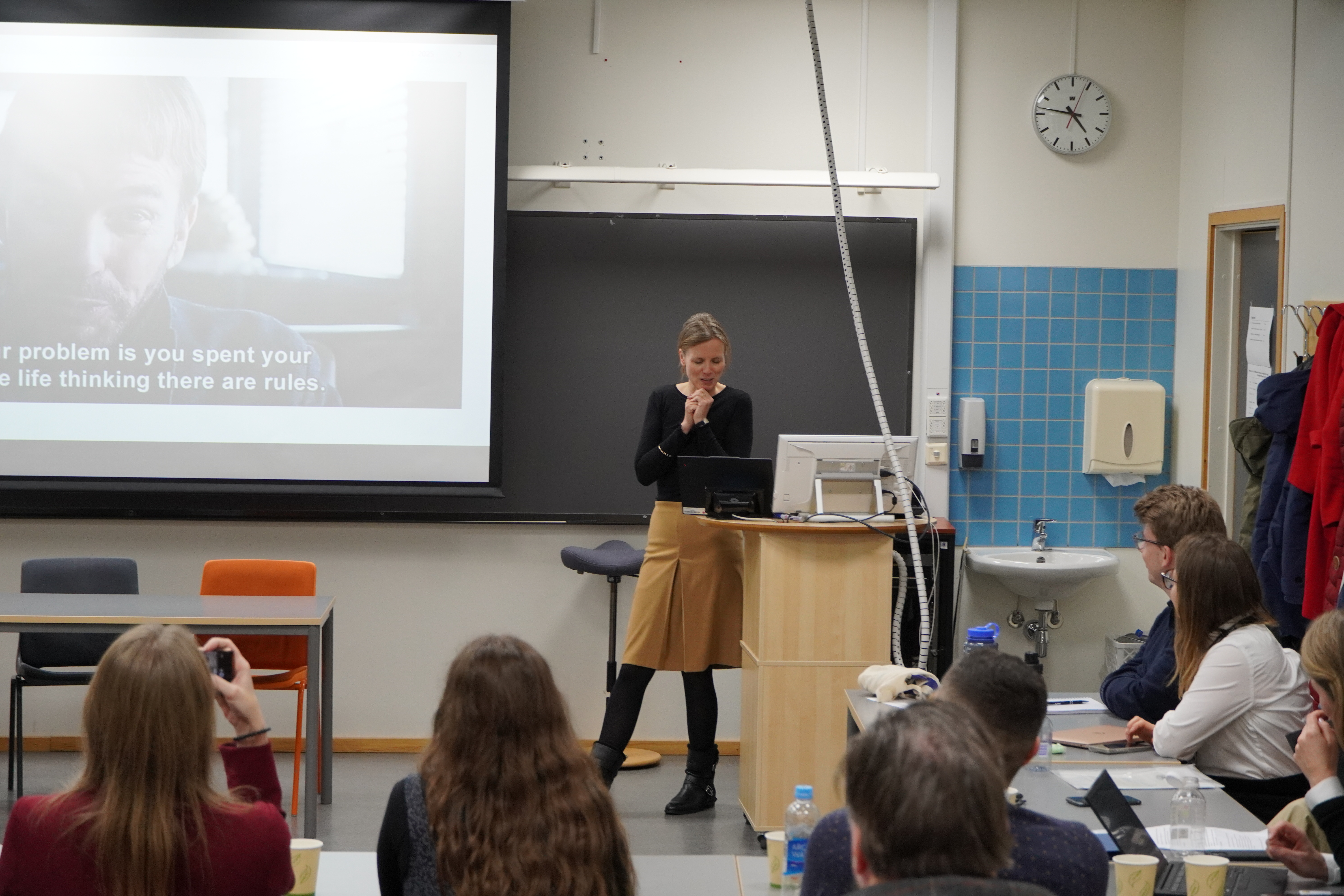 The presenter is looking toward the audience while speaking