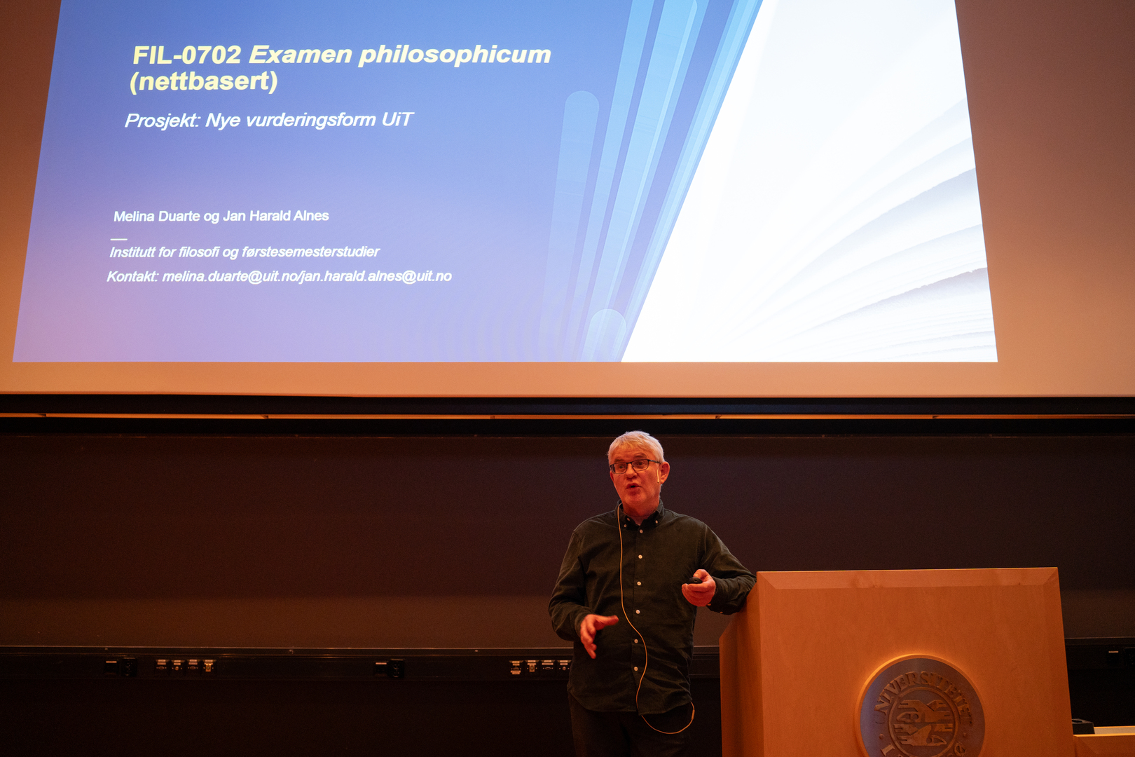 _Jan_Harald_Alnes_09502.jpg Mann holder innlegg foran stor powerpoint-oppslag.