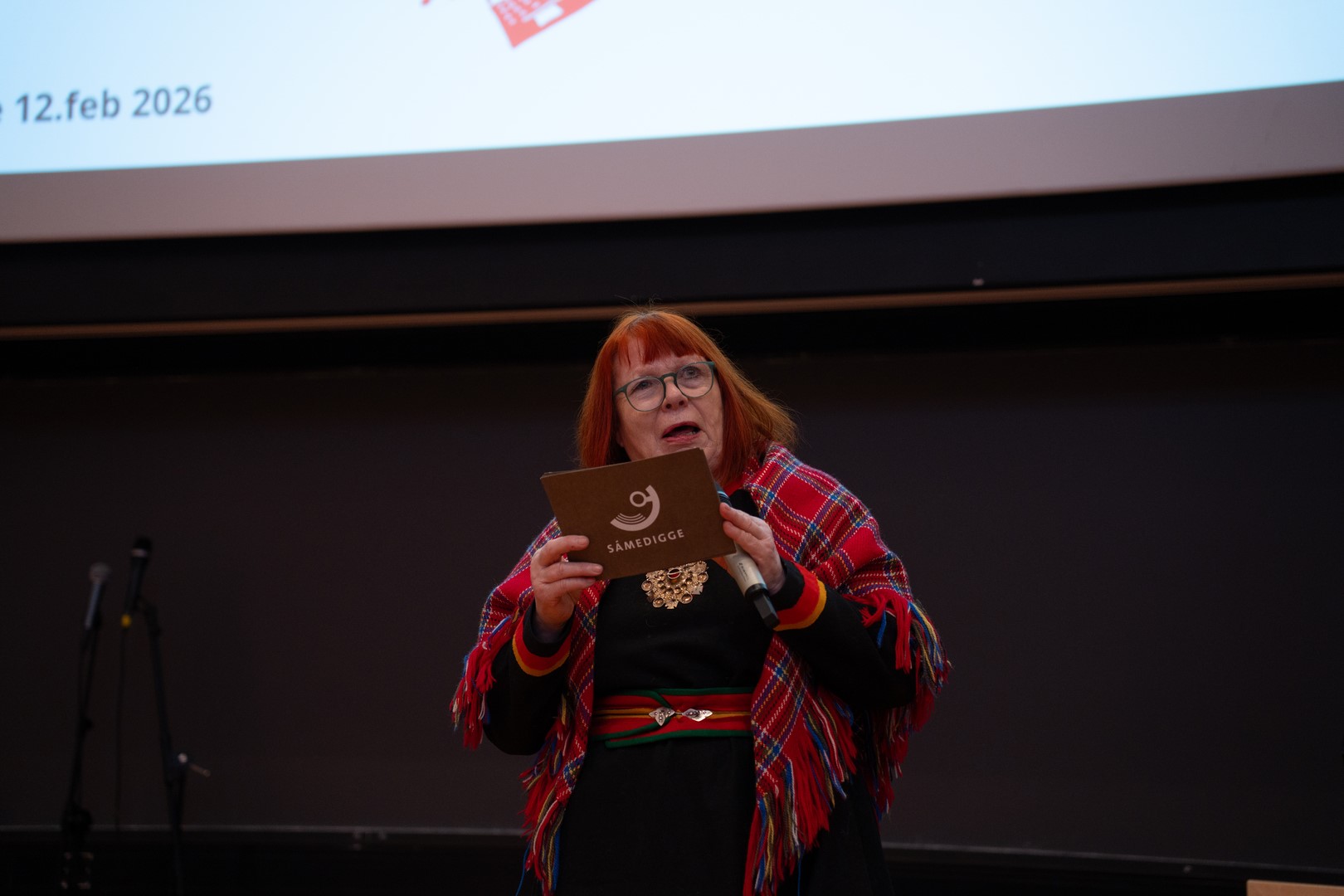 Kvinnelig minister i kofte taler