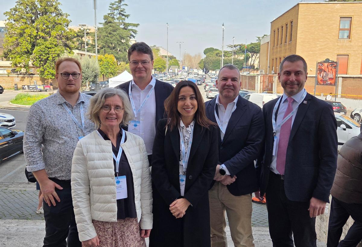 mennesker som st&aring;r samlet utenfor et murbygg