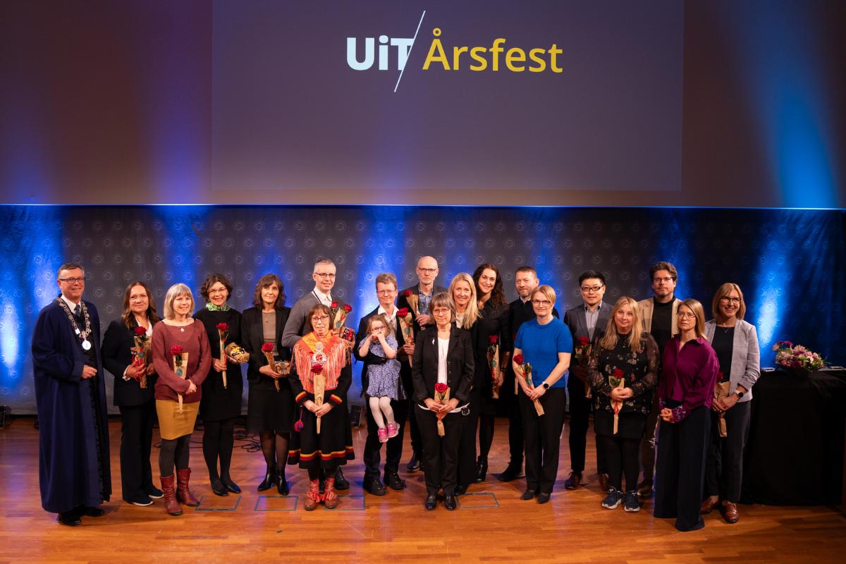 en gruppe pent kledde mennesker fremst i et auditorium